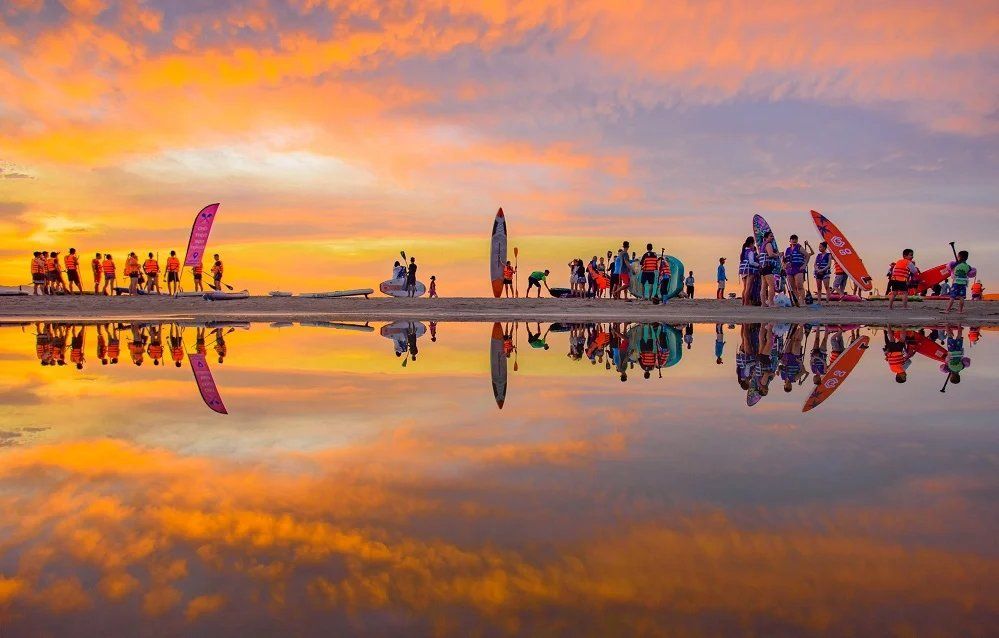 Paddleboarders at golden hour on My Khe Beach, Da Nang