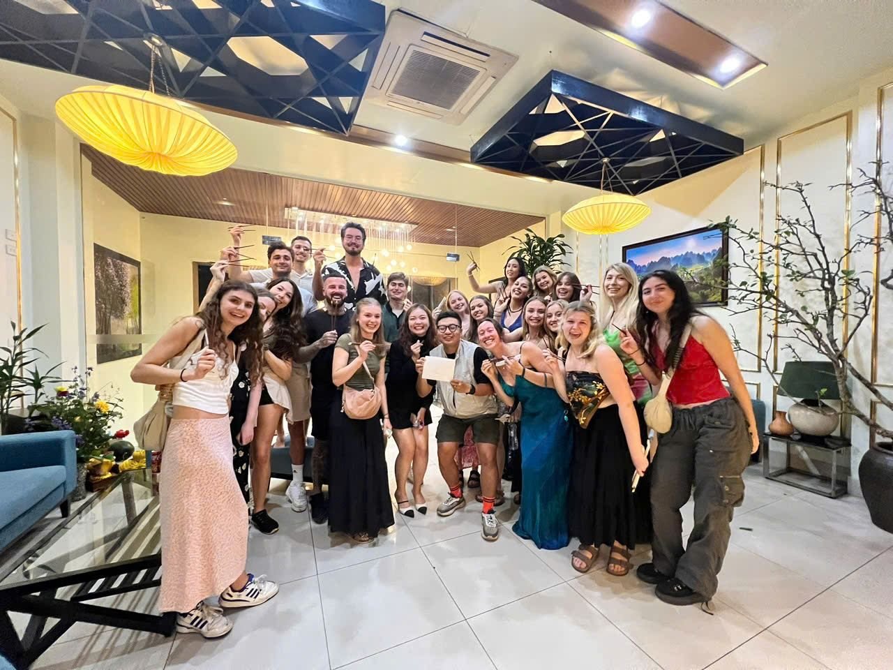 A large travel group celebrating at dinner in Hoi An